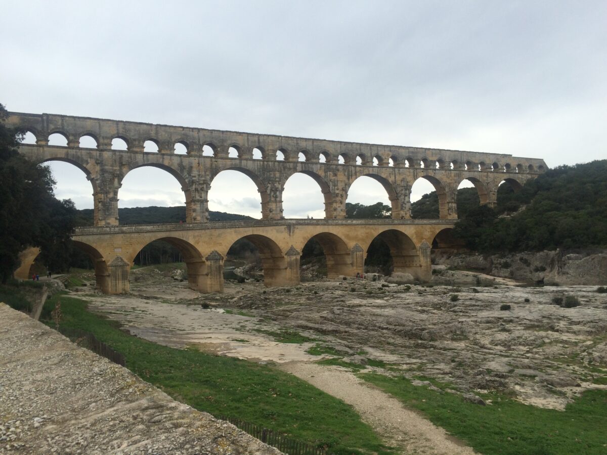 A large roman aquaduct, the Pont du Gard, stretches over a river