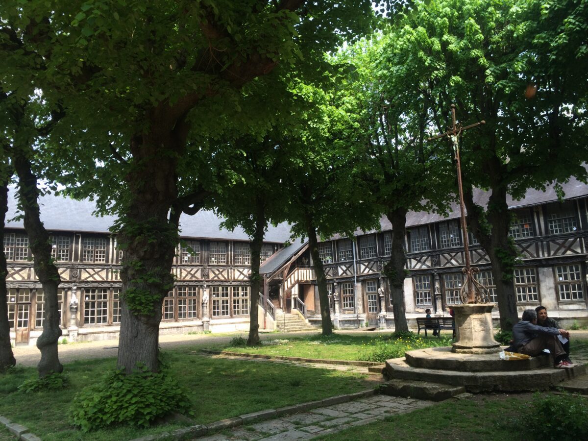 Central lawn with trees surrounded by a wooden two story building